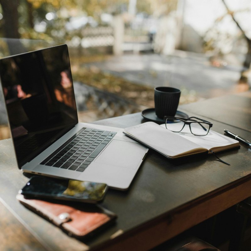 laptop on a table with books and cup near it